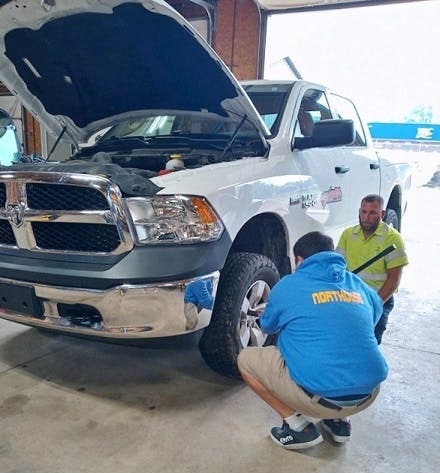 Students learning how to check fluids, tire pressure and other basic auto maintenance